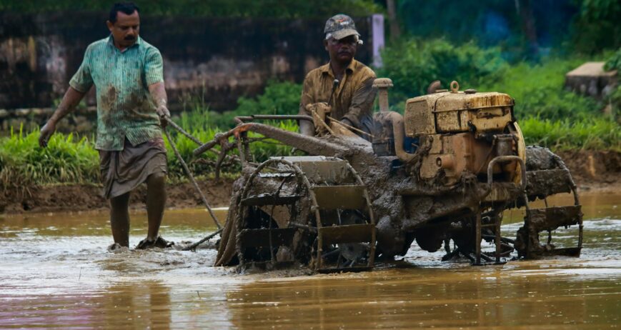 Tractor preparing a flooded paddy field for kharif planting