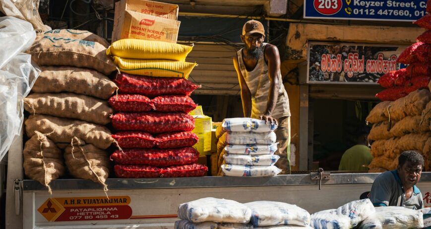 Worker loading sacks onto a truck, the kind of work manpower services for rice mills support